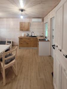 uma cozinha com pisos em madeira, uma mesa e um balcão em Szary Domek w Karkonoszach em Podgórzyn