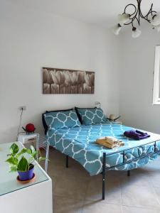 um quarto com uma cama com lençóis azuis e uma mesa em Casina Gentili em Perugia