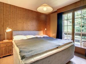 een slaapkamer met een groot bed en 2 ramen bij Crépuscule 5 in Verbier