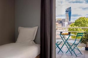 a bedroom with a bed and a balcony with a view at Hôtel Sanso by HappyCulture in Paris
