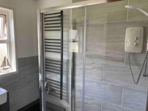 a shower with a glass door in a bathroom at No12 Pats Place - Sleeps 6 - Sea views over Carbis Bay in Carbis Bay