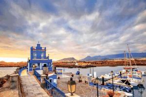 un faro blu accanto a un porto turistico con barche di Beautiful chalet with wifi and free parking ad Arona