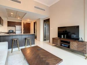 a living room with a large television and a table at Key View - Bay Central in Dubai