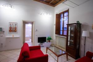 un soggiorno con divano rosso e TV di Appartamento Andrea Amati nel Cuore di Cremona a Cremona