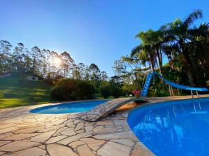 uma piscina com escorrega e um parque infantil em Pousada Green Valley em São Roque