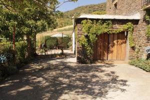 ein Steingebäude mit einer Holztür und einer Einfahrt in der Unterkunft Los Castaños, Vivienda Rural, Capileira in Capileira