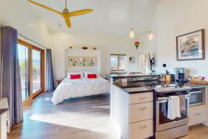 a bedroom with a bed and a kitchen with a ceiling fan at Cottam Pines B in Taos