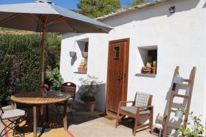 a patio with a table and chairs and an umbrella at Los Castaños, Vivienda Rural, Capileira in Capileira