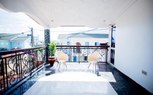 a balcony with two chairs and a view at Aduk Guest House Airport City Accra in Otele