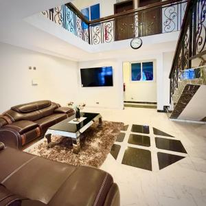 uma sala de estar com um sofá e uma mesa em Aduk Guest House Airport City Accra em Otele