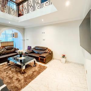 a living room with a couch and a table at Aduk Guest House Airport City Accra in Otele