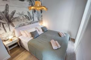 Loulou Apartman - Balatonboglár في بالاتونبوغلار: غرفة نوم عليها سرير وفوط
