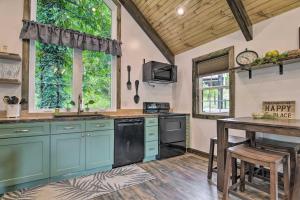 a kitchen with blue cabinets and a table at Pet-Friendly Delta Cabin with Private Hot Tub! in Delta +30 photos