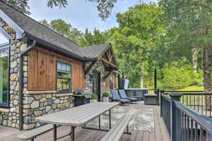 a wooden deck with a picnic table and chairs at Pet-Friendly Delta Cabin with Private Hot Tub! in Delta