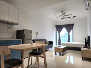 Il comprend une cuisine et un salon avec une table et un canapé. dans l'établissement Infini Suites@ Continew Residence KL, à Kuala Lumpur