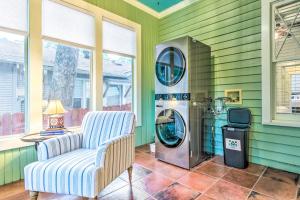 uma sala de estar com uma máquina de lavar roupa e uma cadeira em Colorful Cottage with Deck about 5 Mi to Downtown! em Little Rock