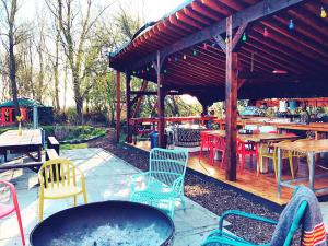 a patio with chairs and tables and a grill at Eco Camping De Helleborus in Groningen