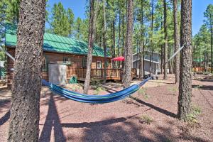 a blue hammock in front of a log cabin at Pinetop-Lakeside Cabin with Deck Hike, Ski and Golf in Pinetop-Lakeside