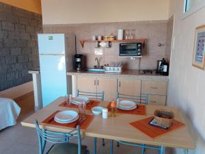 Una pequeña cocina con una mesa y un refrigerador. en Aquamarinas Departamentos, en Playas Doradas