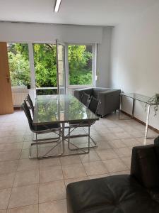 sala de estar con mesa de cristal y sillas en Superbe appartement lumineux et spacieux, en Amberes