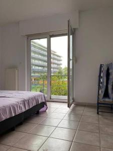 a bedroom with a bed and a large sliding glass door at Superbe appartement lumineux et spacieux in Antwerp