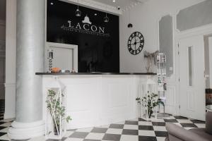 a lobby with a counter with a clock on the wall at Pałac Lacon in Kazimierza Wielka