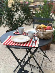una mesa de picnic con una cesta de fruta y platos y tazas en Maison Tassigny, en Meursault