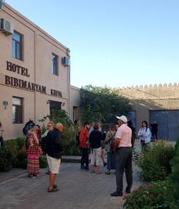 a group of people standing outside of a building at Khiva Bibimariyam in Khiva