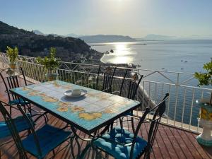 uma mesa e cadeiras numa varanda com vista para a água em MAR-ISA Amalfi Coast em Vietri