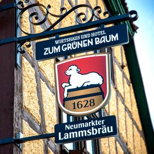 un panneau sur le côté d'un bâtiment avec des panneaux sur celui-ci dans l'établissement Boutique-Hotel Zum Grünen Baum, à Alzenau