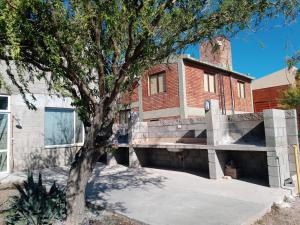 a brick house with a tree in front of it at Aquamarinas Departamentos in Playas Doradas