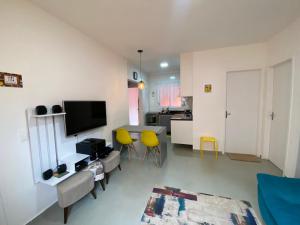 a living room with a table and yellow chairs at Casa em Bertioga condomínio 200 metros da praia in Bertioga