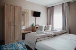 a bedroom with a bed and a desk and a television at Pałac Lacon in Kazimierza Wielka +45 photos