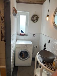 a laundry room with a washing machine and a sink at Haus am See (Teich) 