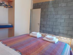 Un dormitorio con una cama con toallas. en Aquamarinas Departamentos, en Playas Doradas