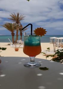 una copa sentada en una mesa junto a la playa en Sea view houses, Praia de Chaves, Boa Vista, Cape Verde, FREE WI-FI en Cabeçadas