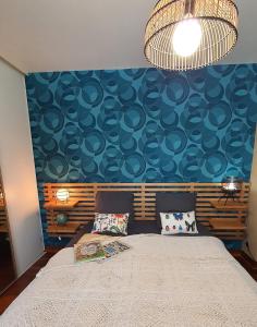 ein Schlafzimmer mit einem großen Bett mit blauer Wand in der Unterkunft A l'Ecole Buissonnière, chambre d'hôtes en Sidobre in Lacrouzette