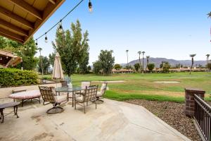 a patio with a table and chairs and an umbrella at Sunshine On My Shoulders Permit# STR2022-0160 in Palm Desert
