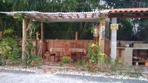 a wooden pergola with a table and chairs at recanto da paz in Una