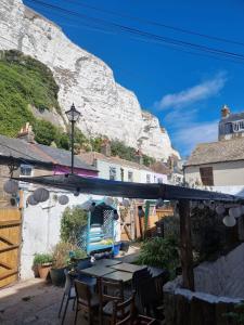 a patio with a table and chairs in front of a mountain at Studio Flat Next to Port and Cliffs in Kent