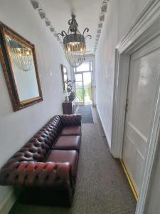 a living room with a leather couch in a hallway at Studio Flat Next to Port and Cliffs in Kent