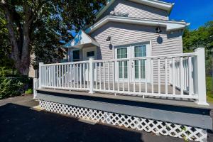 uma pequena casa branca com um corrimão branco em The Ashland Manor em Niagara Falls