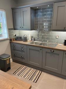 a kitchen with gray cabinets and a sink at St Elmos Townhouse in Derry Londonderry