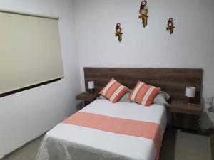 a bedroom with a bed with orange and white pillows at M1010(7) Agradable departamento céntrico en Oaxaca in Oaxaca City