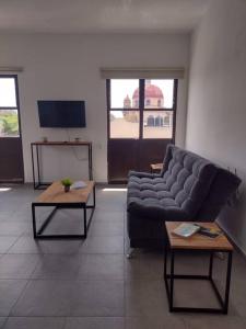 a living room with a couch and two tables at M1010(7) Agradable departamento céntrico en Oaxaca in Oaxaca City