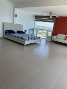 um quarto com uma cama e um sofá num quarto em Departamentos frente al mar en Resort Playa Azul-Tonsupa em Tonsupa