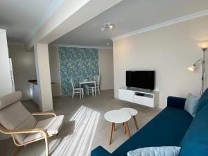 un salon avec un canapé bleu et une télévision dans l'établissement Bungalows Granada Beach, à Playa del Ingles