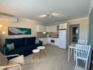 Il comprend un salon avec un canapé bleu et une cuisine. dans l'établissement Bungalows Granada Beach, à Playa del Ingles