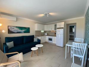 a living room with a blue couch and a kitchen at Bungalows Granada Beach in Playa del Ingles