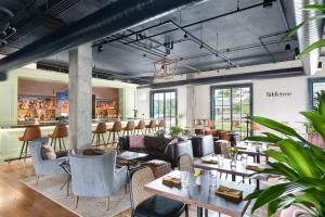 a restaurant with tables and chairs and a bar at Elwood Hotel & Suites in Lexington